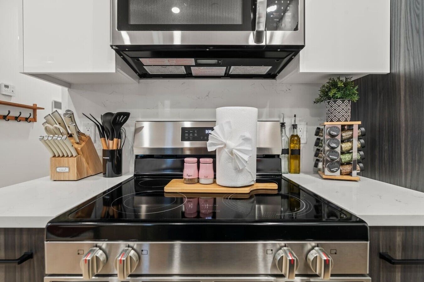 A modern kitchen with a stainless steel stove, a microwave above, and a knife block on the counter.