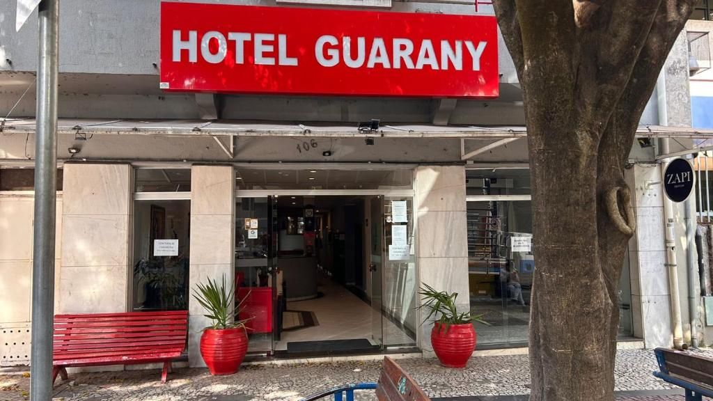 Een hotelentree met een bord waarop 'HOTEL GUARANY' staat.