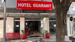 Entrada de un hotel con un cartel que dice 'HOTEL GUARANY'.