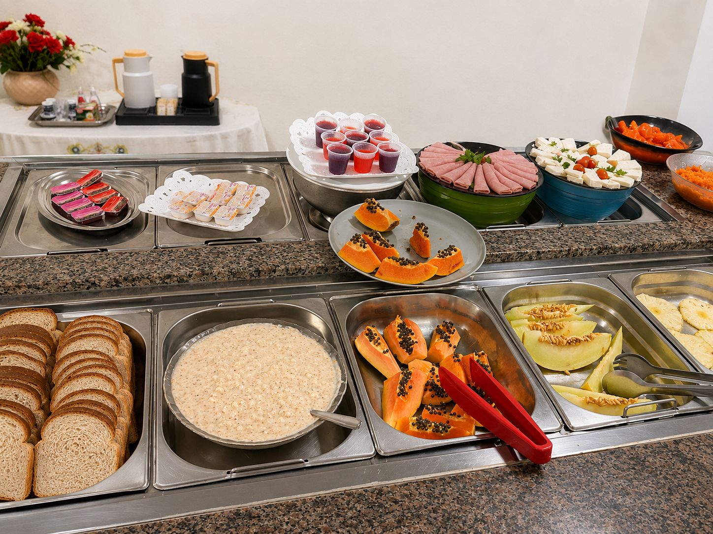 Een buffet met diverse gerechten, waaronder brood, rijst, papaja en andere maaltijden.