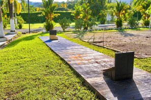 A pathway leading through a landscaped garden with various plants and a bench.
