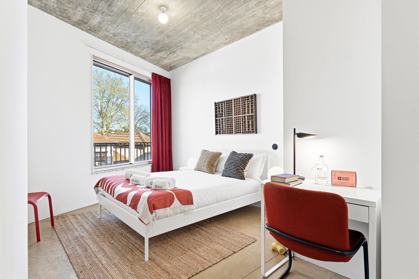 A modern bedroom with a bed, a desk, and a chair.