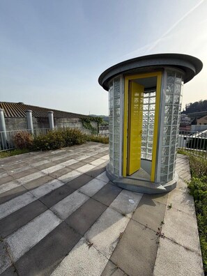 A circular structure with a door, situated on a paved area with a fence and vegetation around. - GuestReady - House of Many Faces - Room 4 (Porto)