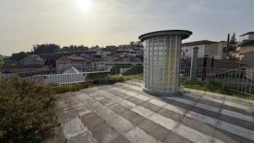 A paved area with a cylindrical structure, possibly a kiosk or monument, surrounded by a metal fence.