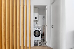 A laundry room with a washing machine, a dryer, and a water heater. - GuestReady - Fantastic Porto Flat (Porto)