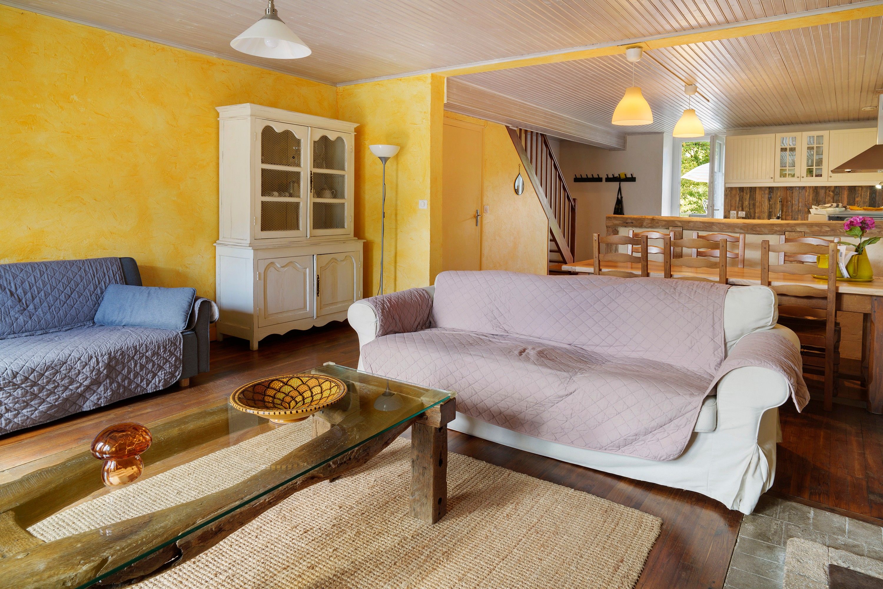 Ein Wohnzimmer mit einer Couch, einem Glastisch und einem Schrank.