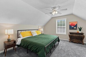 A bedroom with a bed, a nightstand, a lamp, a ceiling fan, a window with blinds, a dresser, and a wall art piece. - Shine Down Lakefront Retreat with Private Dock (Cadiz)