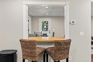 A dining area with a wooden table and two wicker chairs. - Shine Down Lakefront Retreat with Private Dock (Cadiz)
