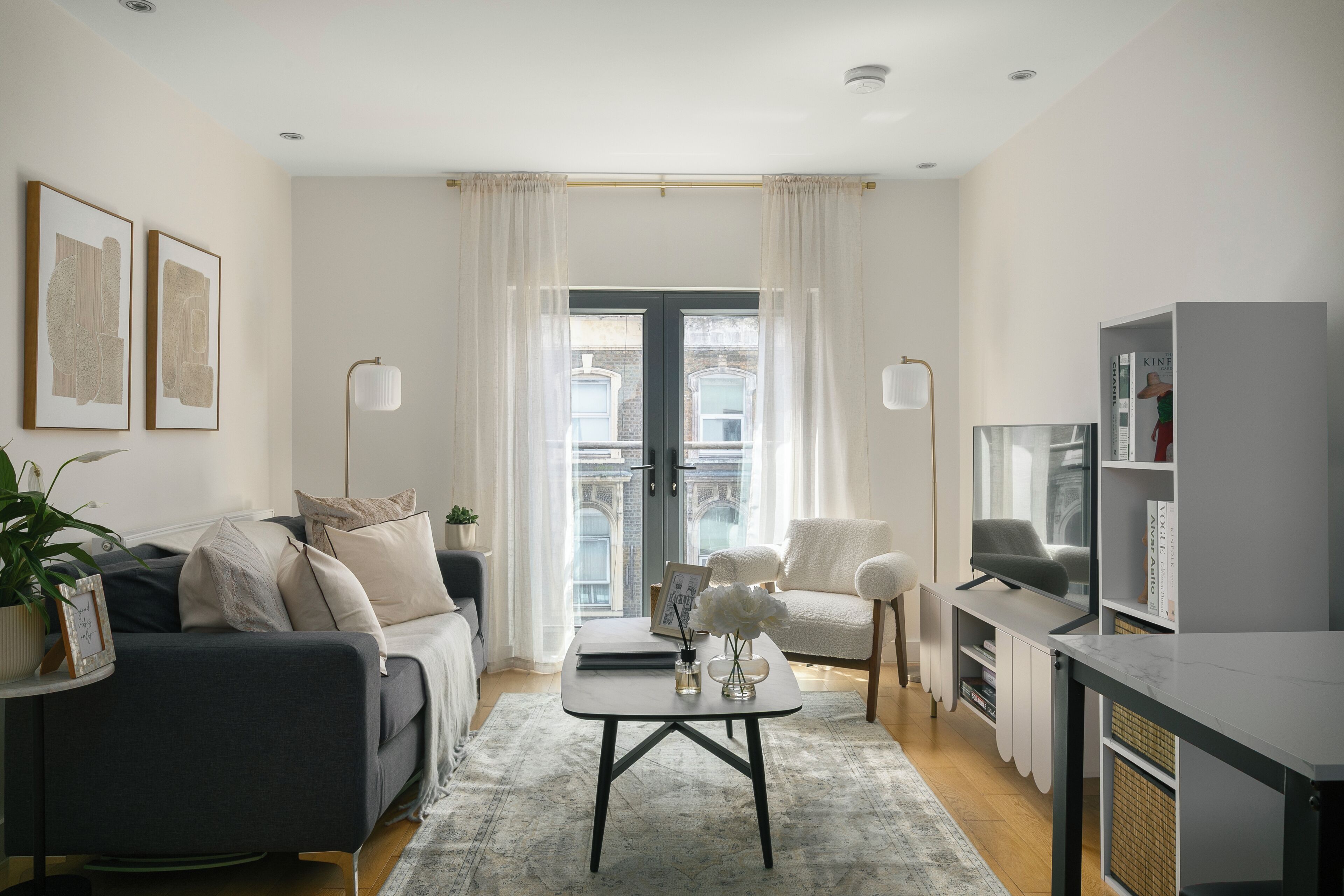 Un salon moderne comprenant un canapé, des fauteuils, une table basse et un meuble pour la télévision.