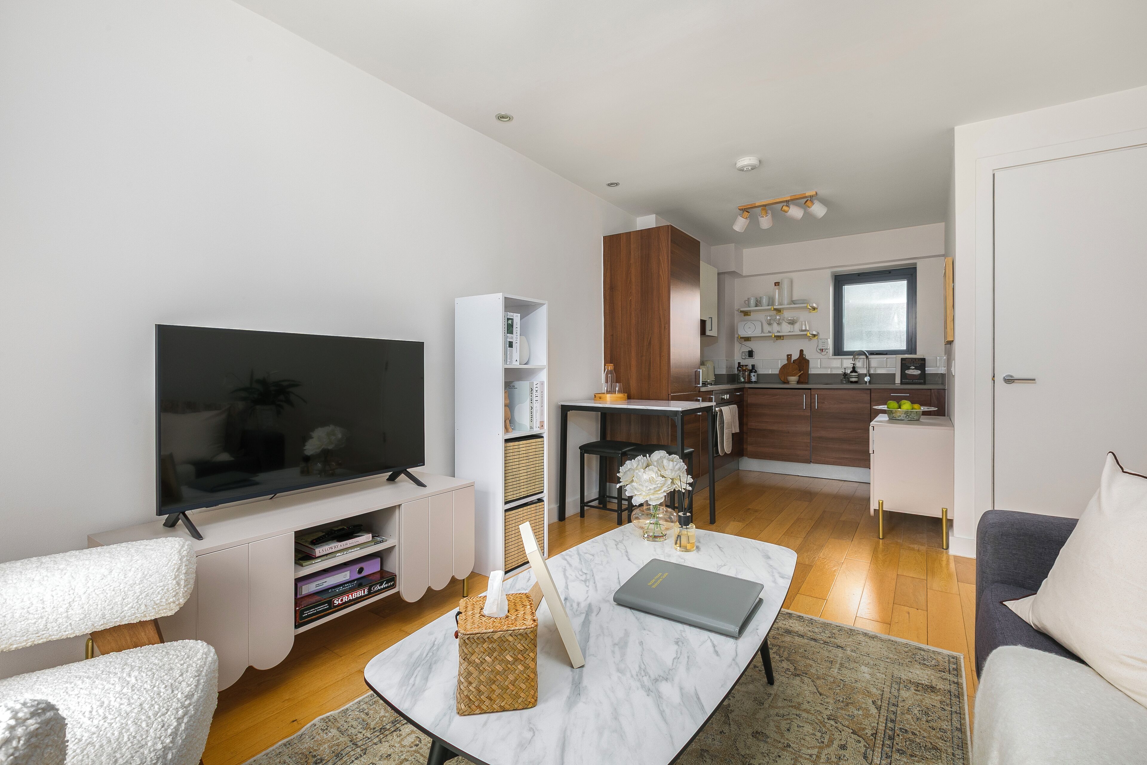 A modern living room with a flat-screen TV, a coffee table, and a sofa.