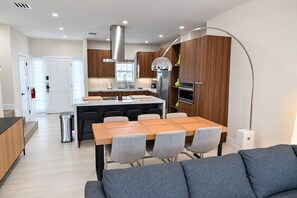 A modern kitchen with a central island, built-in oven, and a pendant light. - Spectacular Waterfront Home - Coral Lagoon Unit #8 (Marathon)