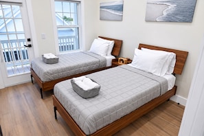 A hotel room with two beds, a balcony, and a view of the sea. - Spectacular Waterfront Home - Coral Lagoon Unit #8 (Marathon)
