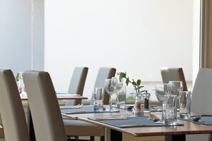 A dining table set with clear glassware, a small plant, and a pepper grinder. - Panthea Resort (Ayia Napa)