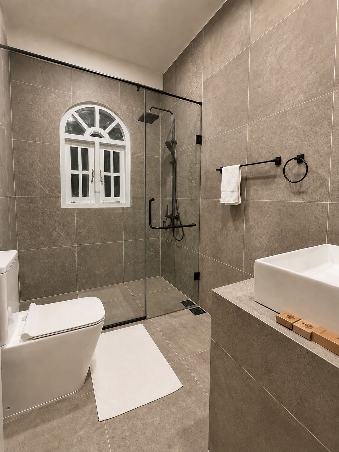 A modern bathroom with a glass-enclosed shower, a freestanding bathtub, and a vanity with a mirror.