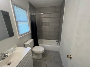 Een badkamer met toilet, wastafel en bad.