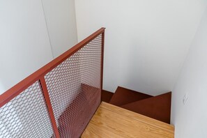 Eine Treppe mit Holzgeländer und einem Maschendrahtzaun.