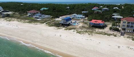 A coastal property with beachfront villas, a swimming pool, and a view of the ocean.