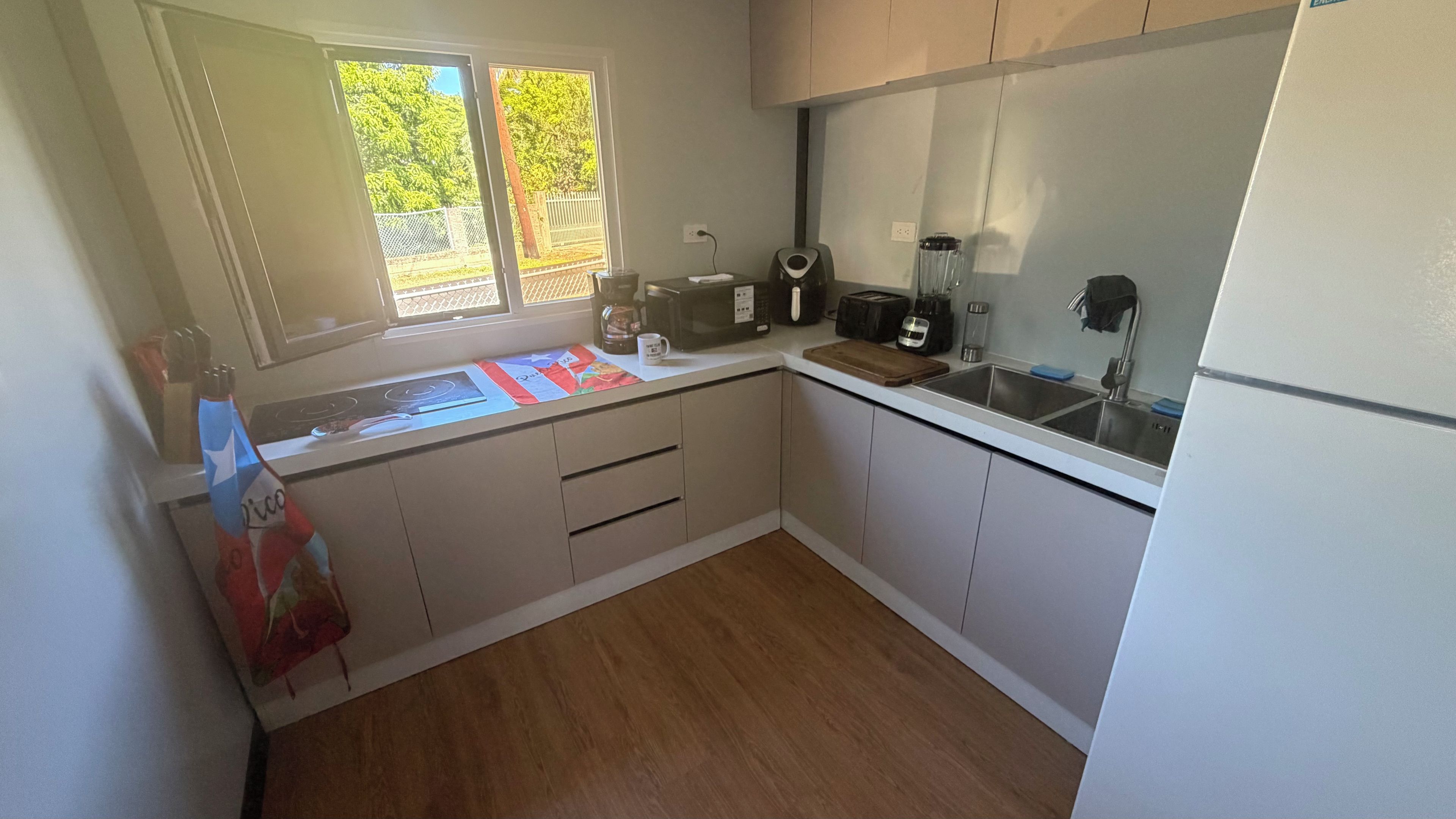 A compact kitchen with a sink, stove, and various appliances.