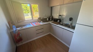 A compact kitchen with a sink, stove, and various appliances. - 3-br house, Vega Baja with AC and next to natural preserve. 4 minutes to beach (Vega Baja)