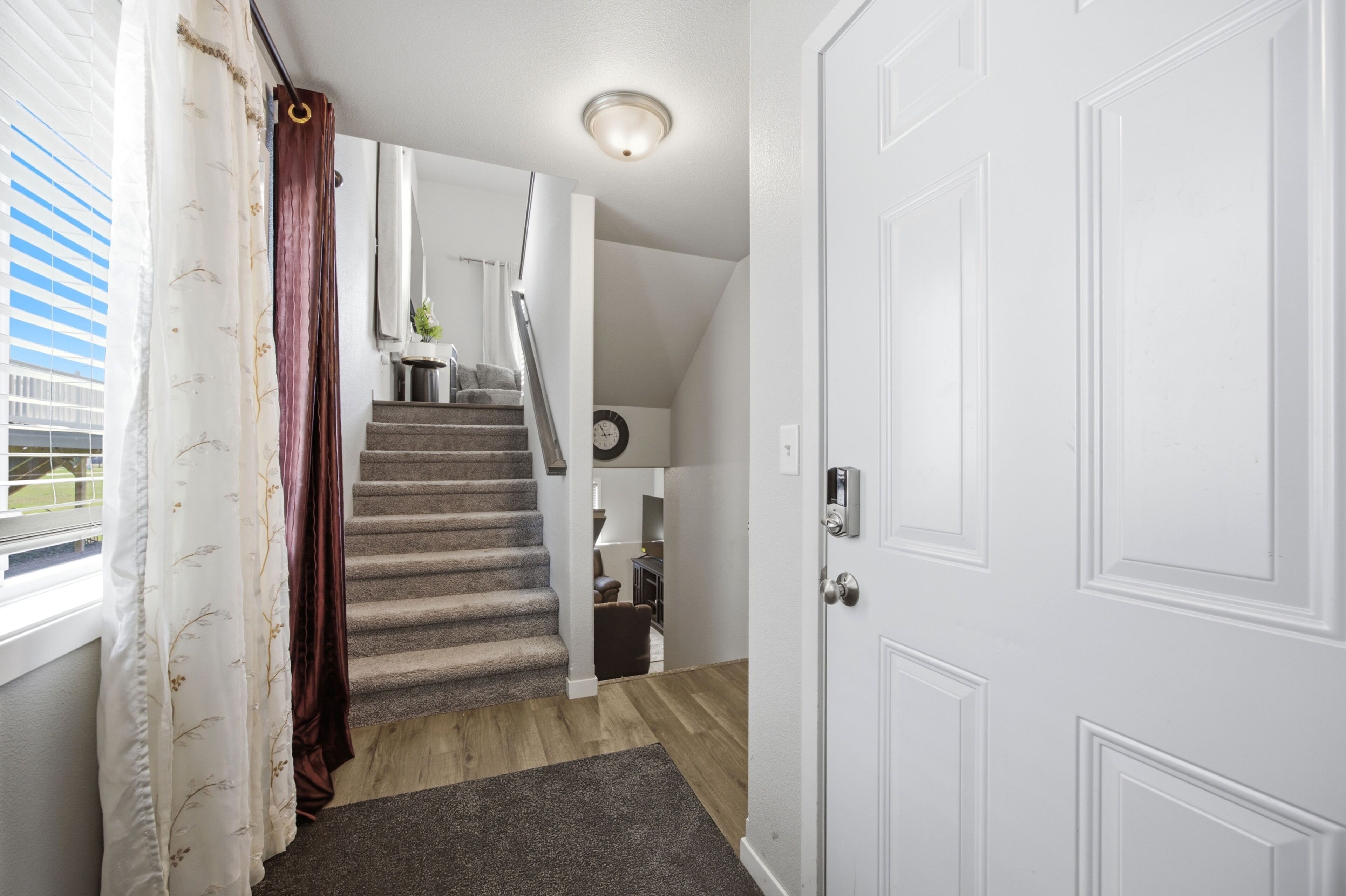 A staircase leading to a second floor with a door on the right and a window on the left.