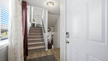 A staircase leading to a second floor with a door on the right and a window on the left.
