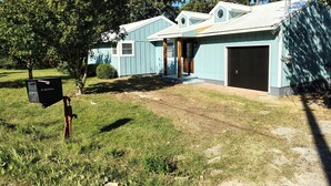 A single-story house with a garage, a front porch, and a mailbox.