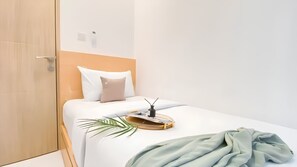 A hotel room with a bed, a bedside table, a lamp, and a door. - Tokyo Riverside Ocean Pearl Apartment (kabupaten Tangerang)