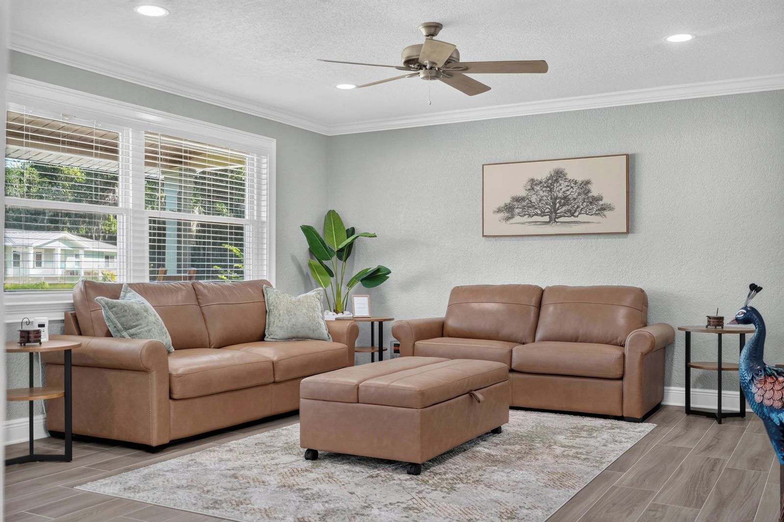 A living room with two sofas, a coffee table, and a ceiling fan.