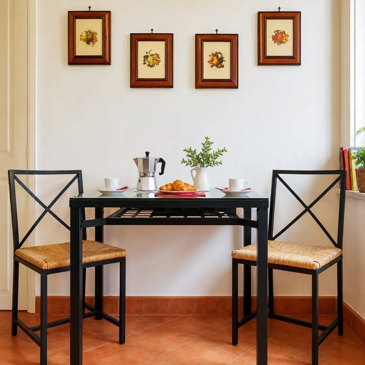 Un'area pranzo con un tavolo nero, due sedie, una moka, un croissant e una pianta in vaso.