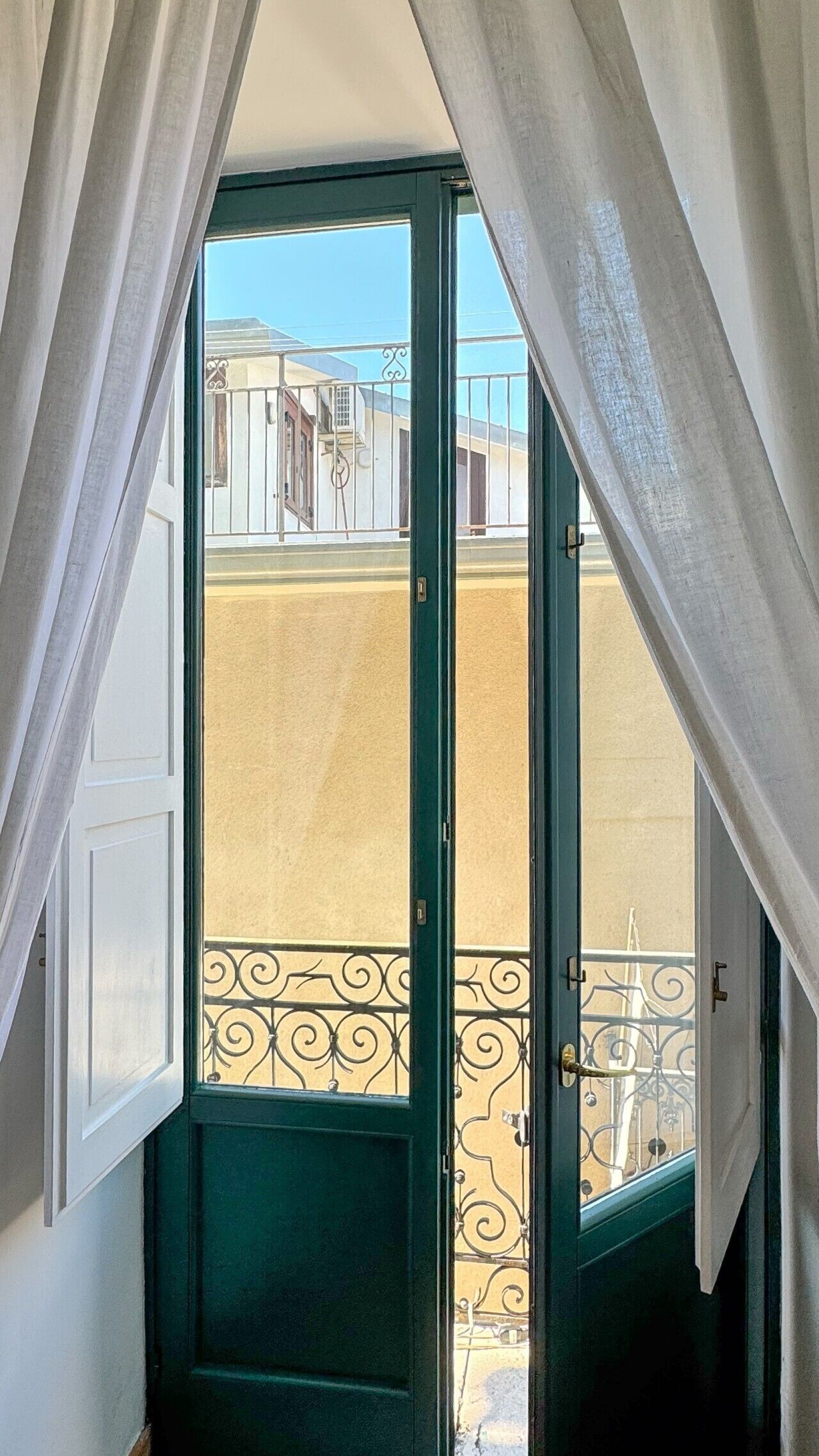 A room with a sliding glass door leading to an outdoor balcony with a metal railing.