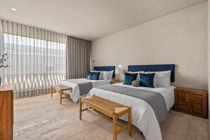 A hotel room with two beds, a wooden bench, a nightstand, and a large window with curtains. - Oceanfront Penthouse with Private Rooftop Pool (Higuera Blanca)
