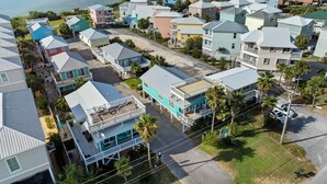 A coastal residential area with houses featuring balconies and a swimming pool. - Coastal Retreat- steps from the beach, pool included (Gulf Shores)