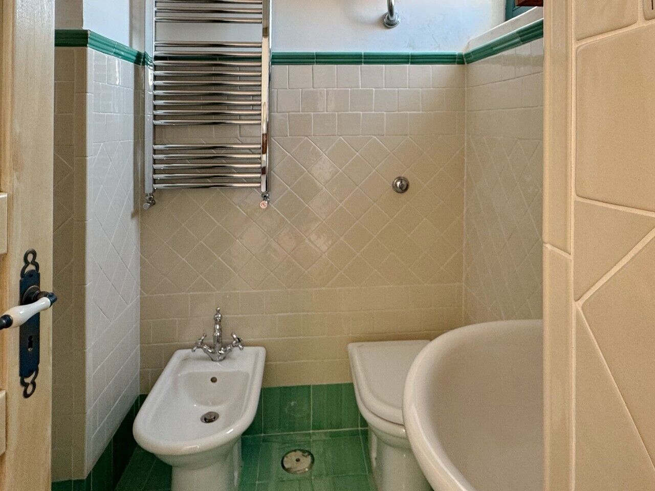 Et badeværelse med vask, toilet og badekar.