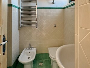 Un baño con lavamanos, inodoro y bañera.