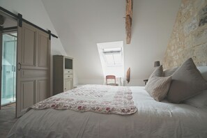 A bedroom with a bed, a window, a chair, and a wardrobe.