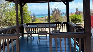 Um gazebo de madeira com vista para o mar.