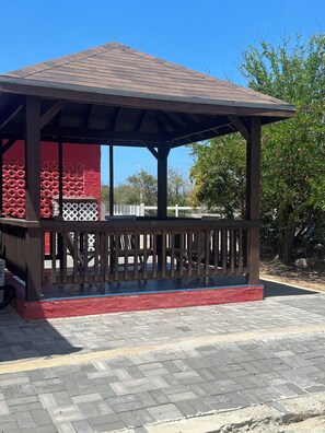 A gazebo with a tiled roof and a wooden railing.