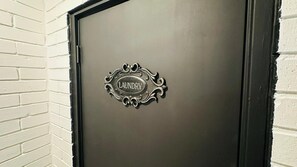 A door with a metal sign that reads 'LAUNDRY.'