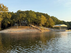 A lakeside property with a dock, a covered pavilion, and a house surrounded by trees. - Emerald Point On Grand (Jay)