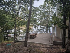 A lakeside property with a covered patio, outdoor seating, and a dock. - Private Lakefront 3BR Retreat 2.5 Bath with private dock for your boat (Jay)