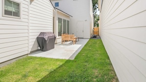 A residential backyard with a patio, a barbecue grill, and a wooden bench. - South College Retreat - King + Office + Garage (Lafayette)