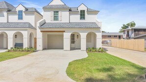 A two-story residential building with a central entrance, arched doorways, and a covered driveway. - South College Retreat - King + Office + Garage (Lafayette)