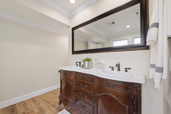 Une salle de bain avec un meuble-lavabo double, un grand miroir et une serviette accrochée au mur.