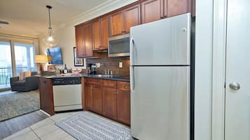 A kitchen with wooden cabinets, a stainless steel refrigerator, a microwave, and a dishwasher.