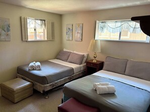 A hotel room with two beds, a small table with a lamp, a bench, and artwork on the walls. - Rustic mountain cabin with lakeviews (South Lake Tahoe)