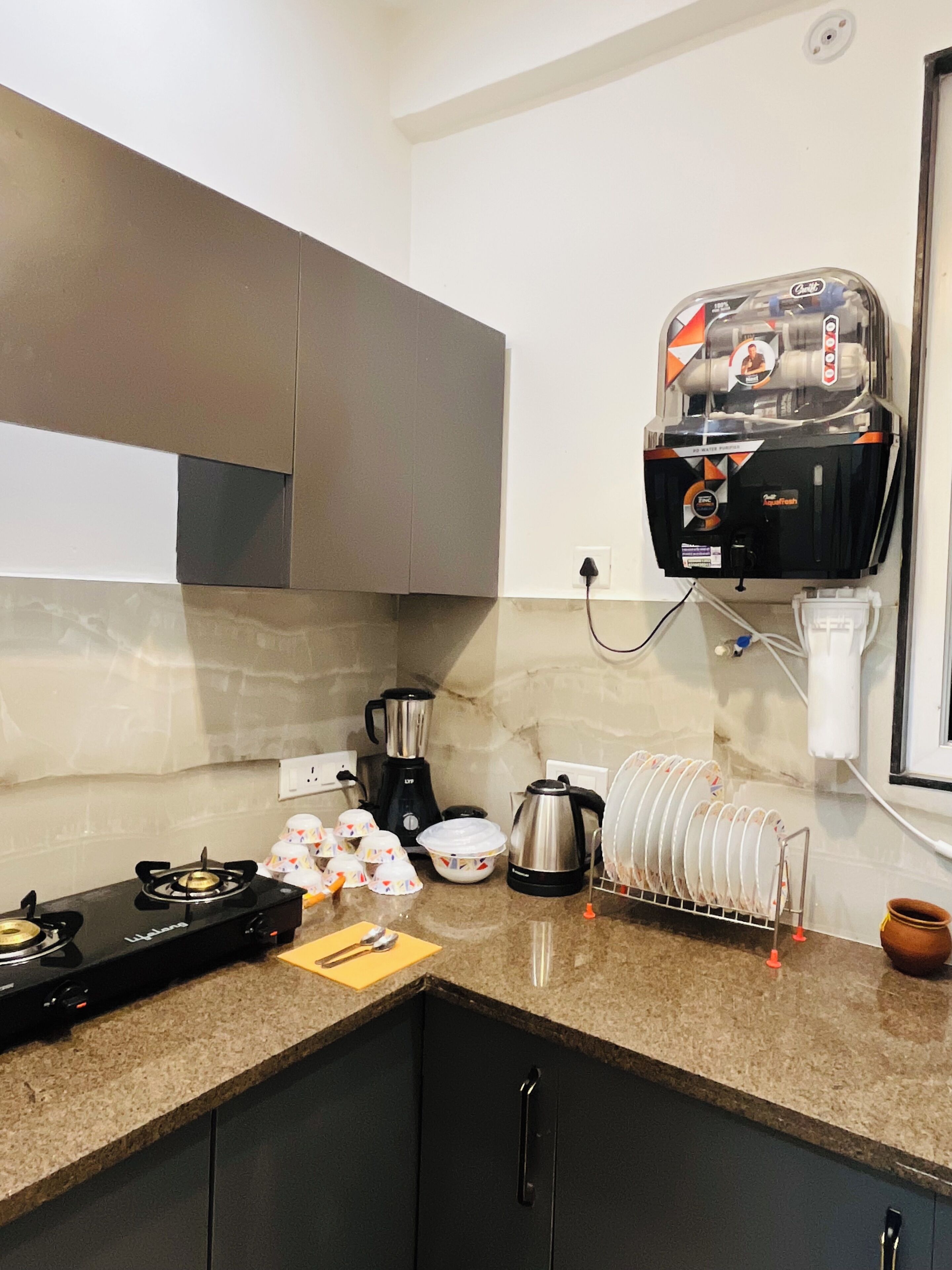 Cozinha equipada com fogão a gás, cafeteira e utensílios de cozinha.