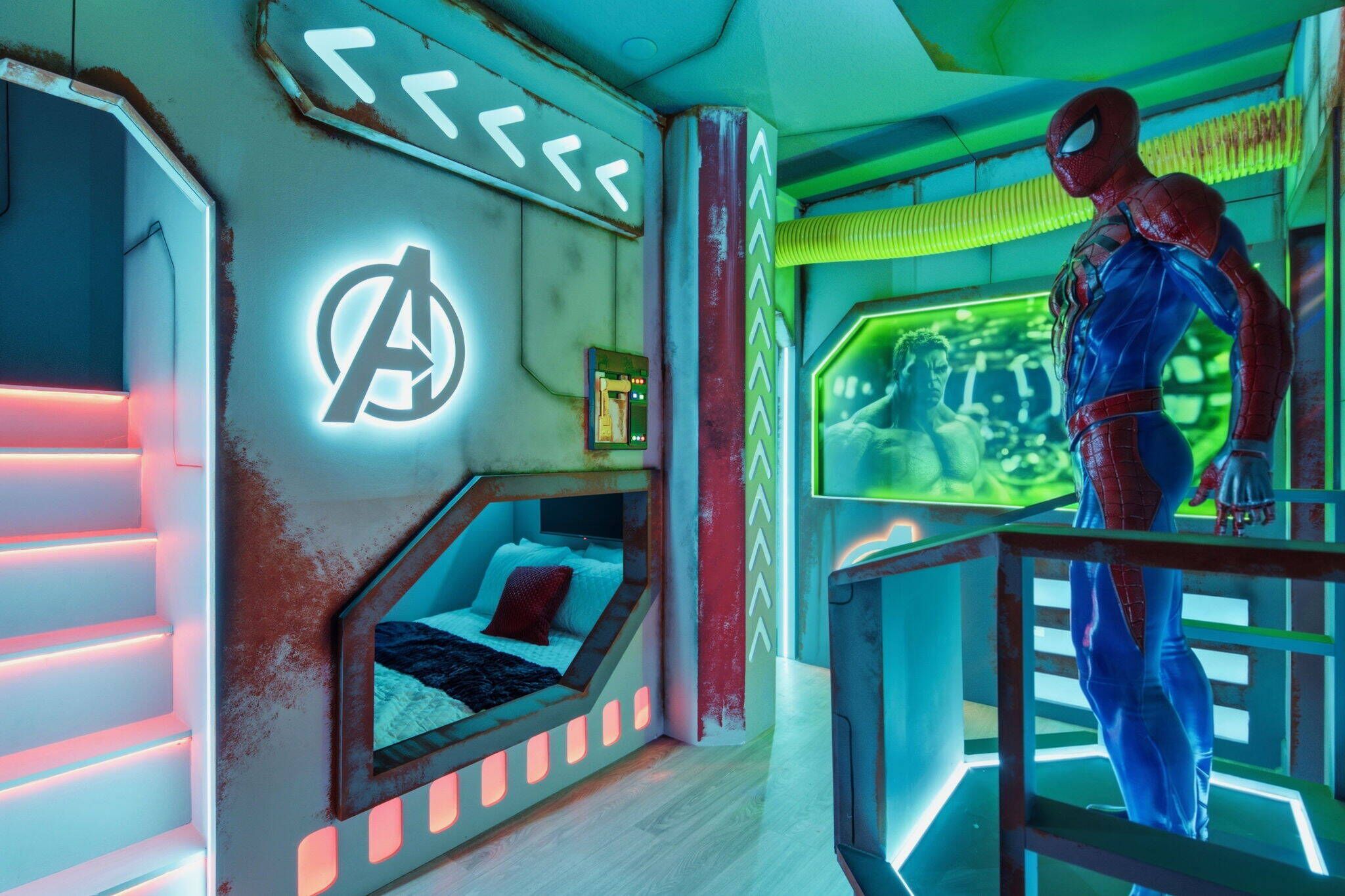 A room with a bed, a neon Avengers logo, and a large screen displaying a character.