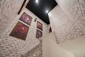 A room with brick walls, a white staircase, and framed pictures on the wall. - 15BR Your Best Vacation Starts Here (11037PG) (Orlando)