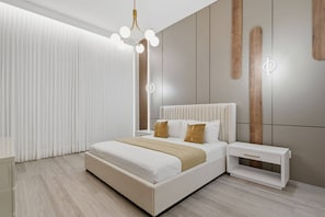 A modern bedroom with a large bed, bedside tables, a hanging light fixture, and a wooden accent wall. - 15BR Your Best Vacation Starts Here (11037PG) (Orlando)