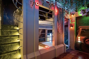 A bunk bed with a window, surrounded by greenery and a Jurassic Park themed decor. - 15BR Your Best Vacation Starts Here (11037PG) (Orlando)